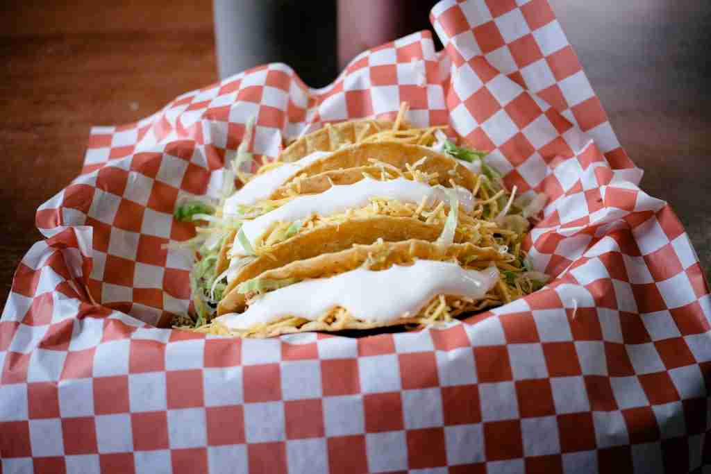 27 Fun Facts About Taco Bell (Saber Mas) 5 burger with green vegetable on red and white checkered table cloth