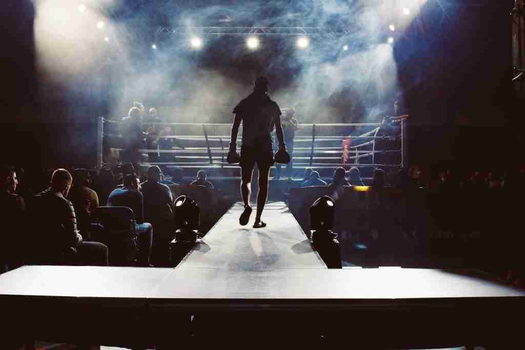 24 Boxing Facts That Will Surprise You 1 man standing and walking going on boxing ring surrounded with people