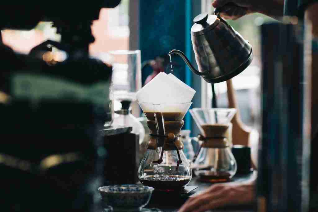26 Fun Facts About Coffee | From Beans to Strange Uses 1 Barista pouring coffee into a glass container another Fun facts about coffee.