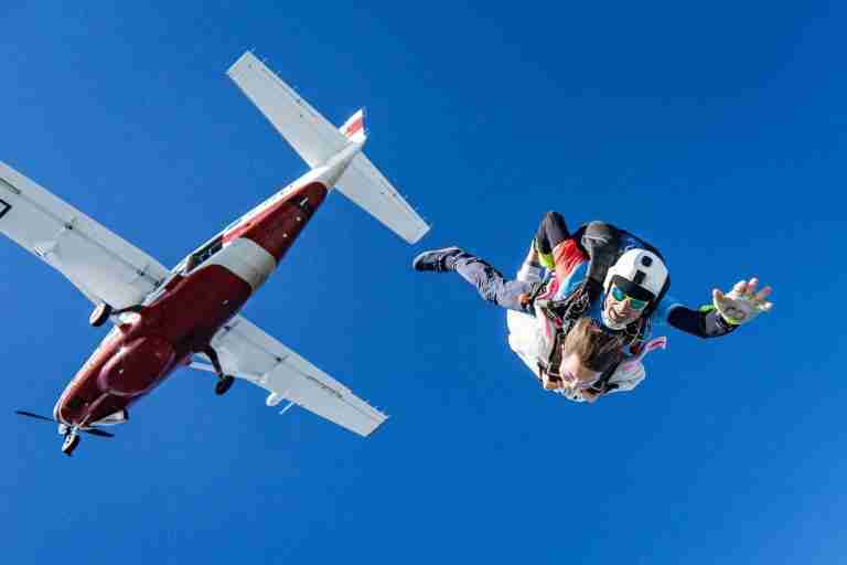 white and red airplane in mid air during daytime