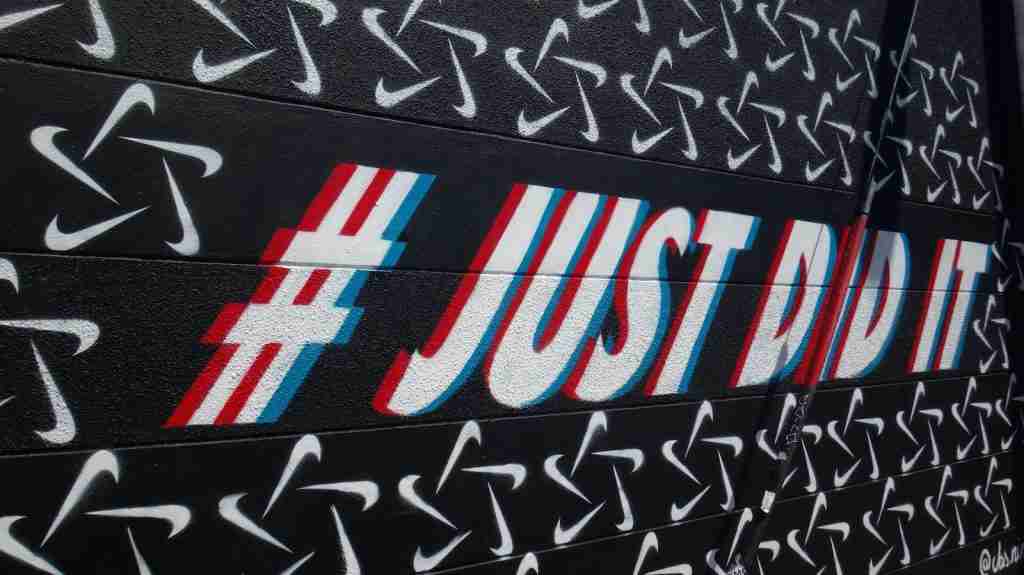 24 Interesting Facts About Nike (Just Know It) 4 Just Do It on a Nike-logoed wall - Discover interesting facts about Nike effortlessly.