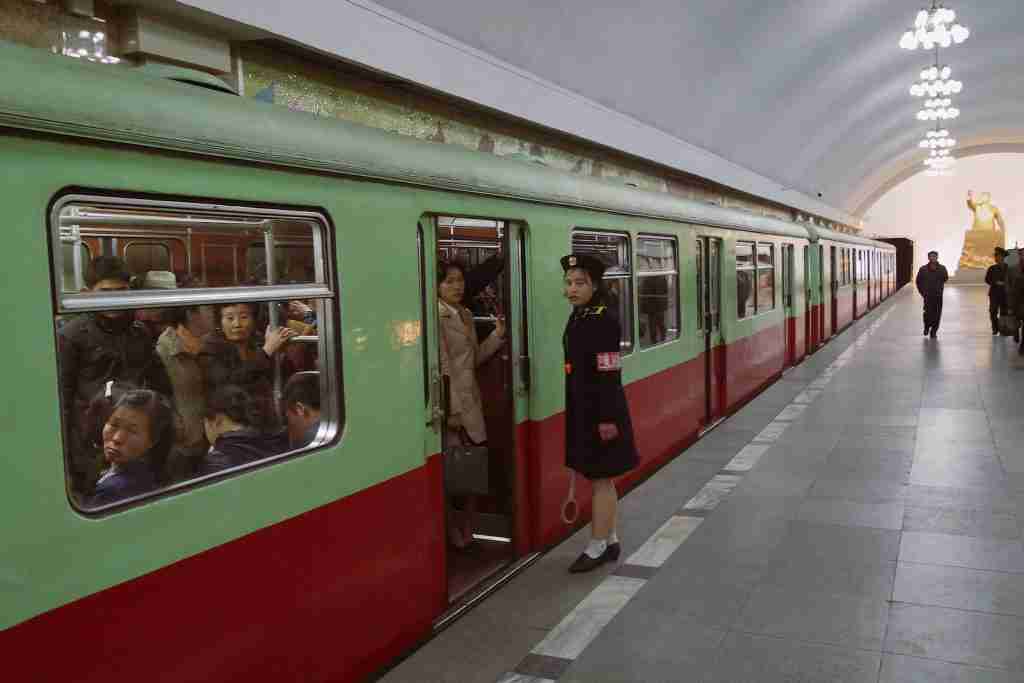 27 Fun Facts About North Korea That You Didn't Know 2 People in North Korea engage in red and white train activities during the daytime, showcasing unique and fun facts about North Korea.