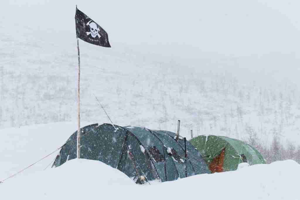 26 Fun Facts About Pirates | Sailing the Seas 3 Colorful tents of expedition with flag with skull placed on ground in highland in snowstorm