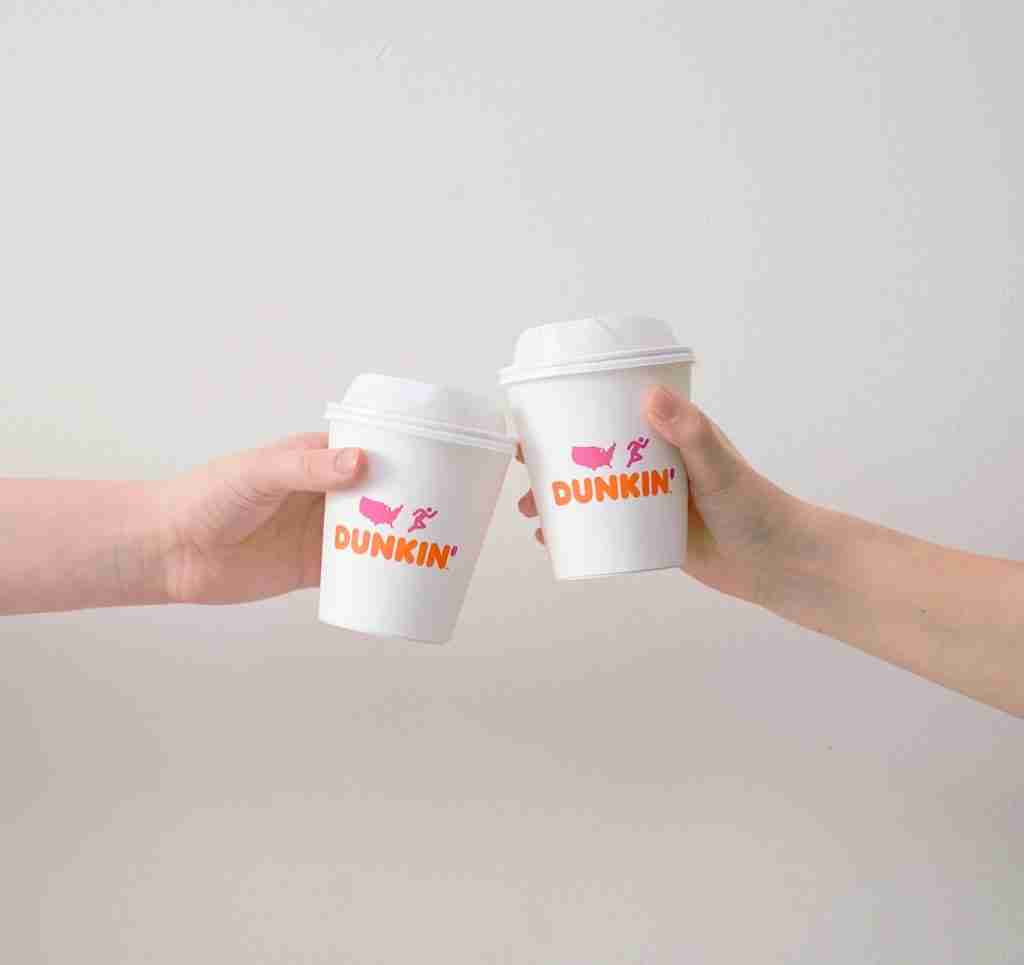 20 Fun Facts About Dunkin' Donuts: From Doughnuts to Coffee 1 two people with white Dunkin' Donuts paper cups
