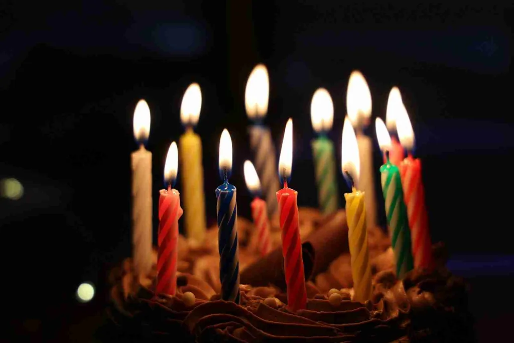 23 Fun Facts About Birthdays You Should Know 4 lighted candles on brown cake