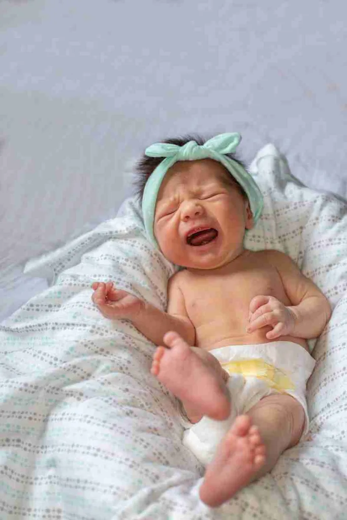 22 Fun Facts About Newborns | Eye-Opening Details 4 a baby crying while laying on a bed