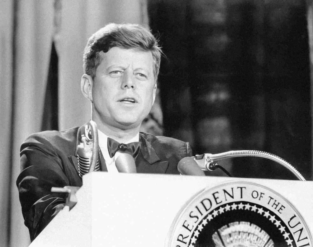 29 Fun Facts about JFK | The Untold Stories and Trivia 2 a man in a suit and tie standing at a podium