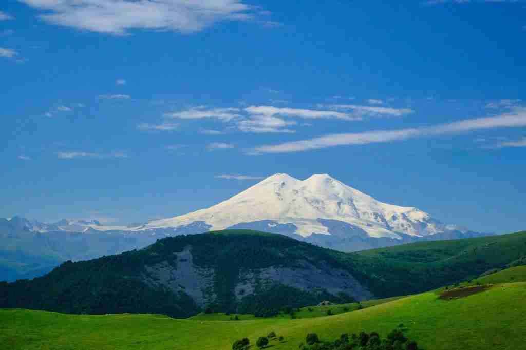sky, mountains, Mount elbrus, with lush greenery and snow on mountain showcasing interesting facts about Mount Elbrus