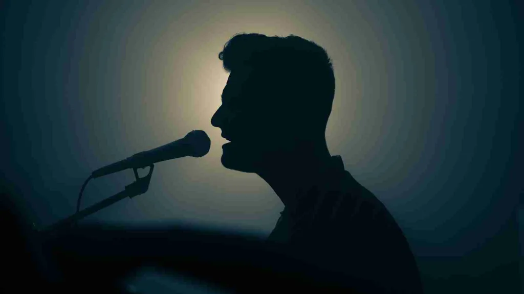 a silhouette of a man singing into a microphone