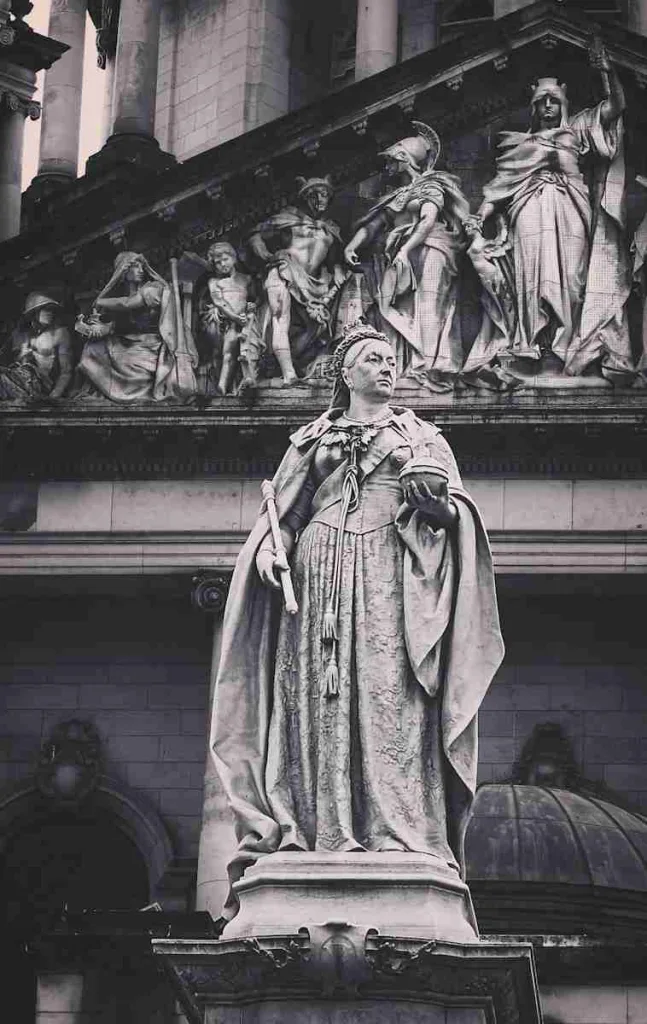a black and white photo of a statue in front of a building
