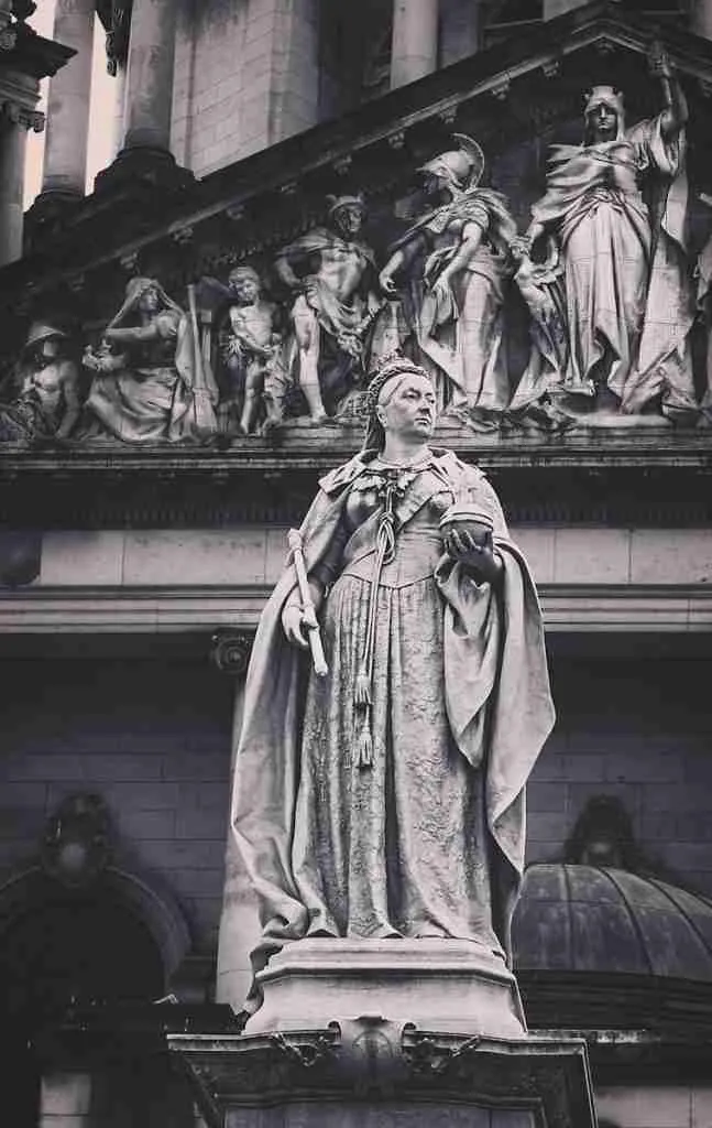 a black and white photo of a statue in front of a building